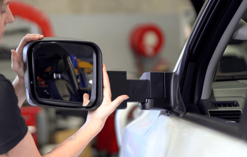 Person installing a car side mirror on a vehicle